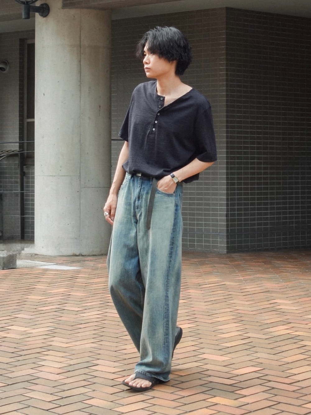 ブラック系のサンダル、ブルー系のデニムパンツ、ブラック系のTシャツ/カットソーを着用したメンズの夏コーディネートの1枚目の写真