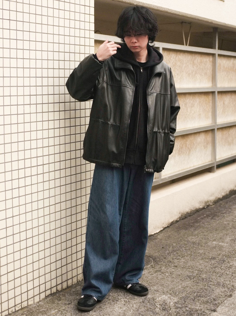 ブラック系のスニーカー、ブルー系のデニムパンツ、ブラック系のブルゾンを着用したメンズの春コーディネートの1枚目の写真