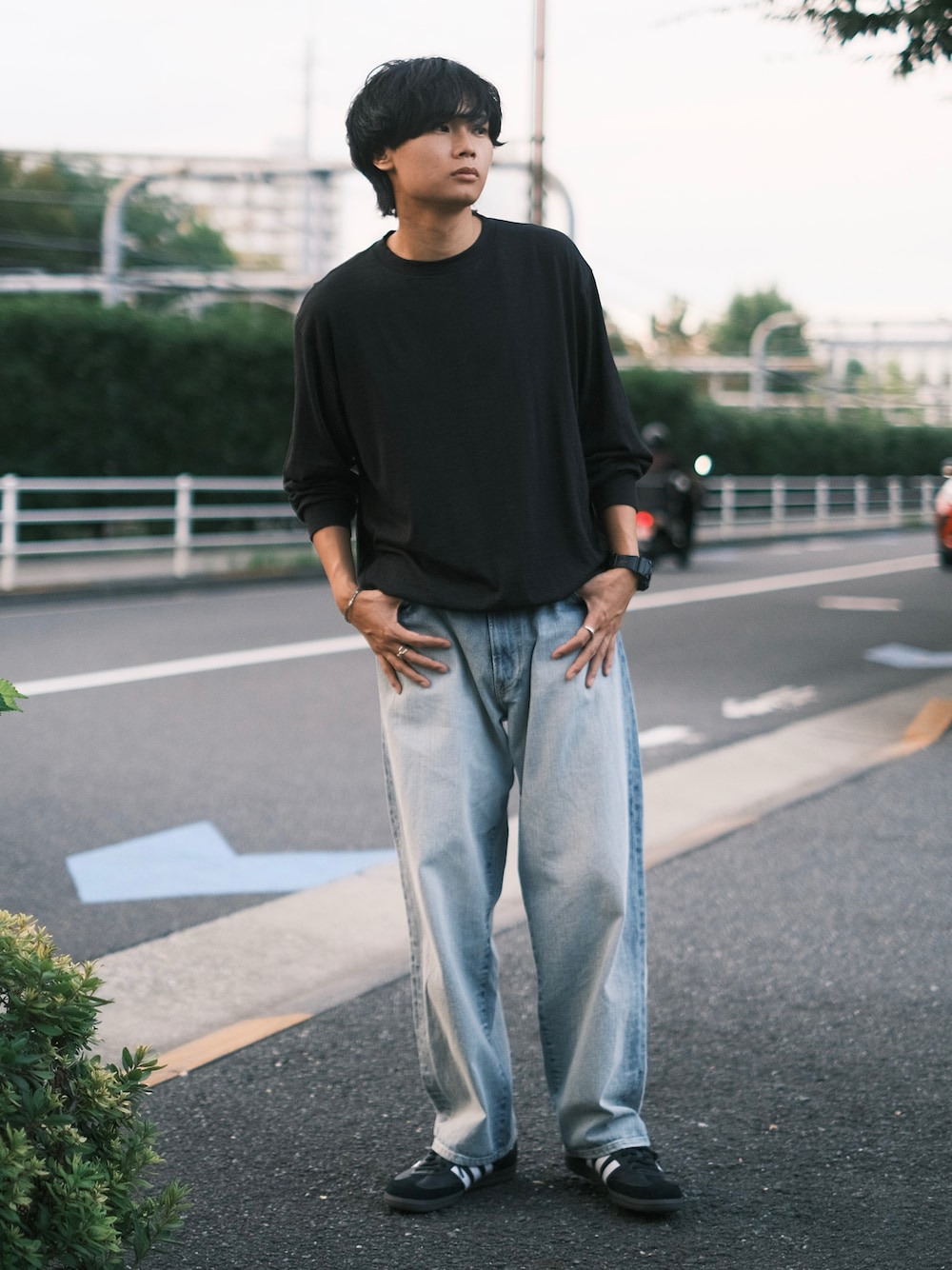 ブラック系のTシャツ/カットソー、ブラック系のスニーカー、ブルー系のデニムパンツを着用したメンズの秋コーディネートの1枚目の写真