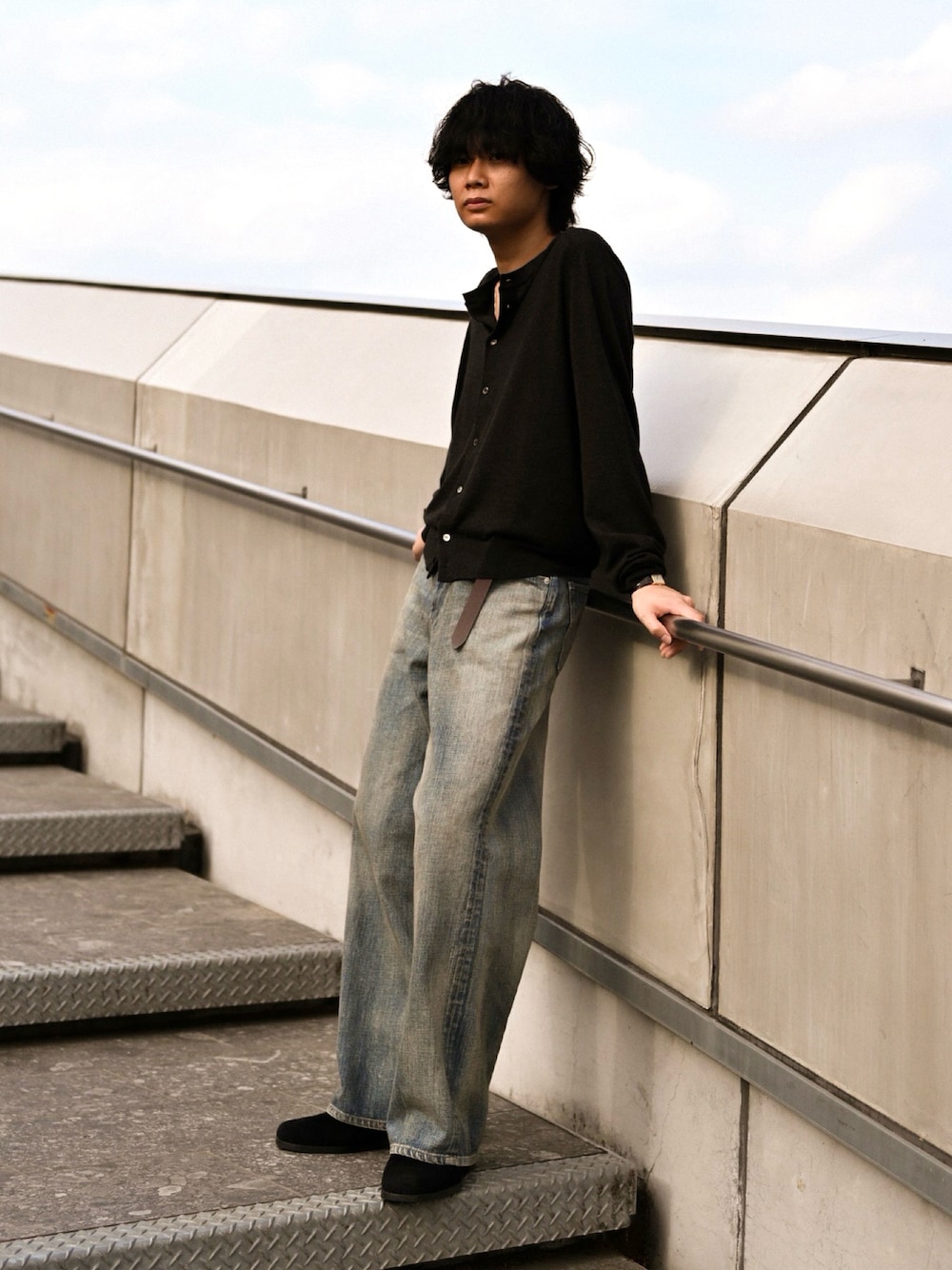ブルー系のデニムパンツ、ブラック系のブーツ、ブラック系のカーディガン/ボレロを着用したメンズの春コーディネートの1枚目の写真