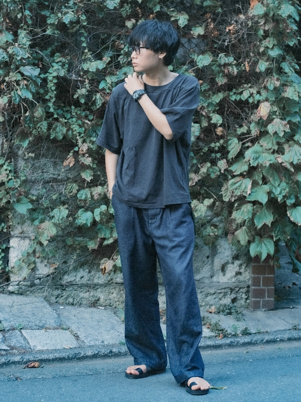 ブラック系のTシャツ/カットソー、ブルー系のデニムパンツ、ブラック系のサンダルを着用したメンズの夏コーディネートの1枚目の写真
