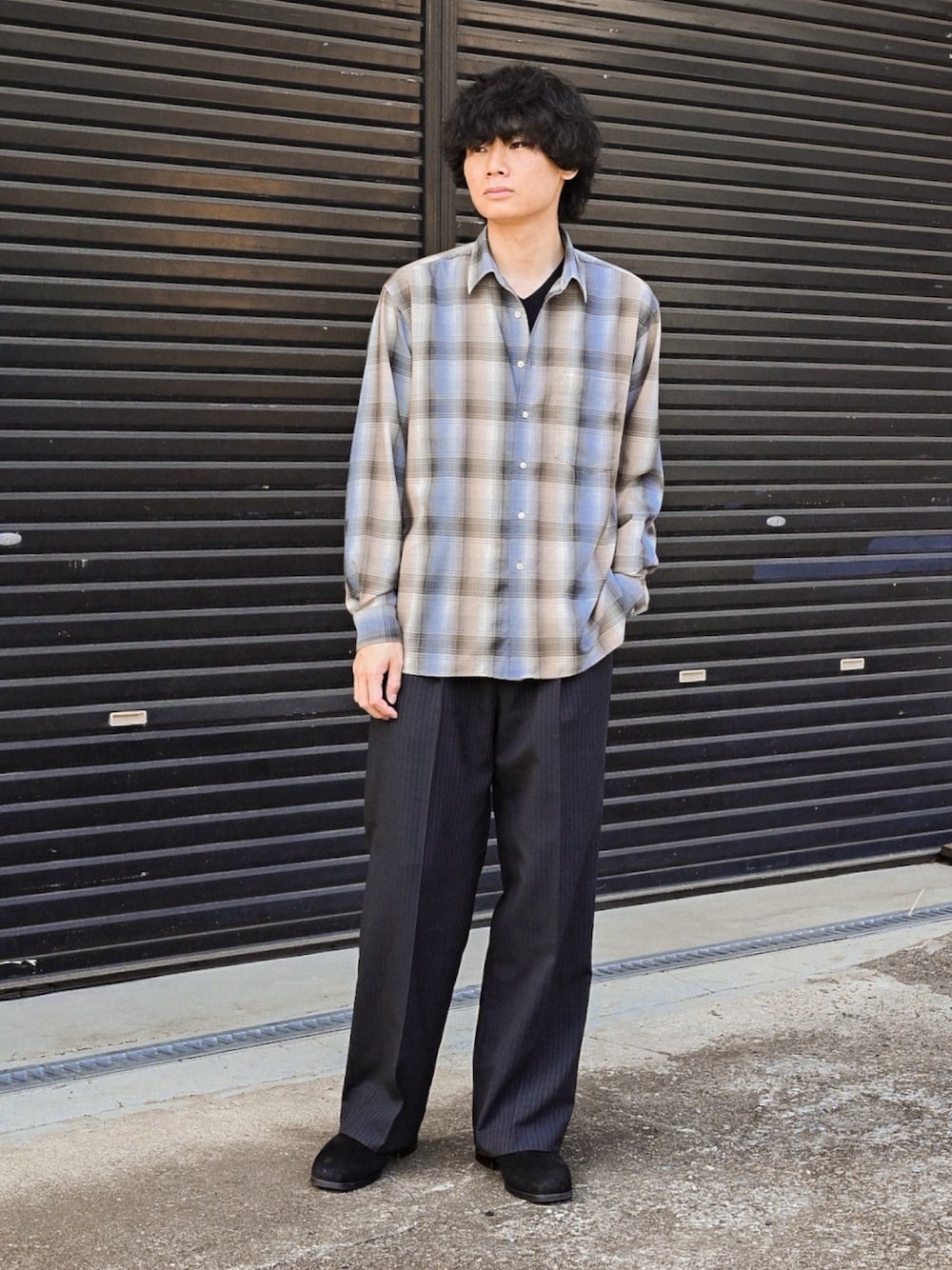 ブラック系のブーツ、ブルー系のシャツ/ブラウス、ブラック系のニット/セーターを着用したメンズの春コーディネートの1枚目の写真