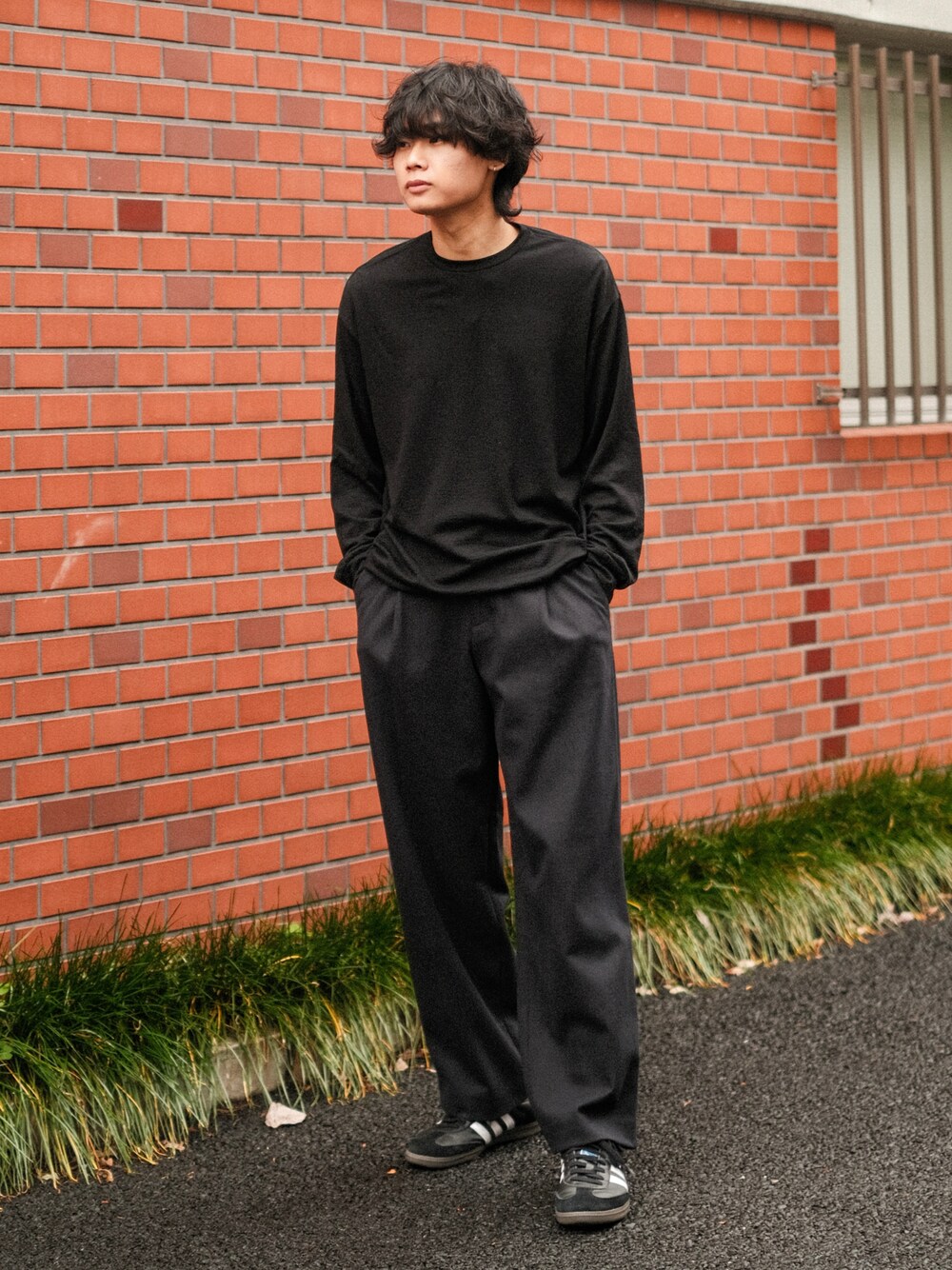 ブラック系のTシャツ/カットソー、ブルー系のスラックス、ブラック系のスニーカーを着用したメンズの冬コーディネートの1枚目の写真