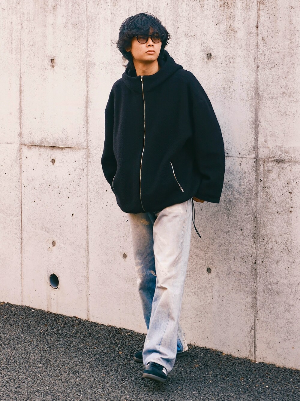 ブラック系のブルゾン、ブルー系のデニムパンツ、ブラック系のスニーカーを着用したメンズの冬コーディネートの1枚目の写真