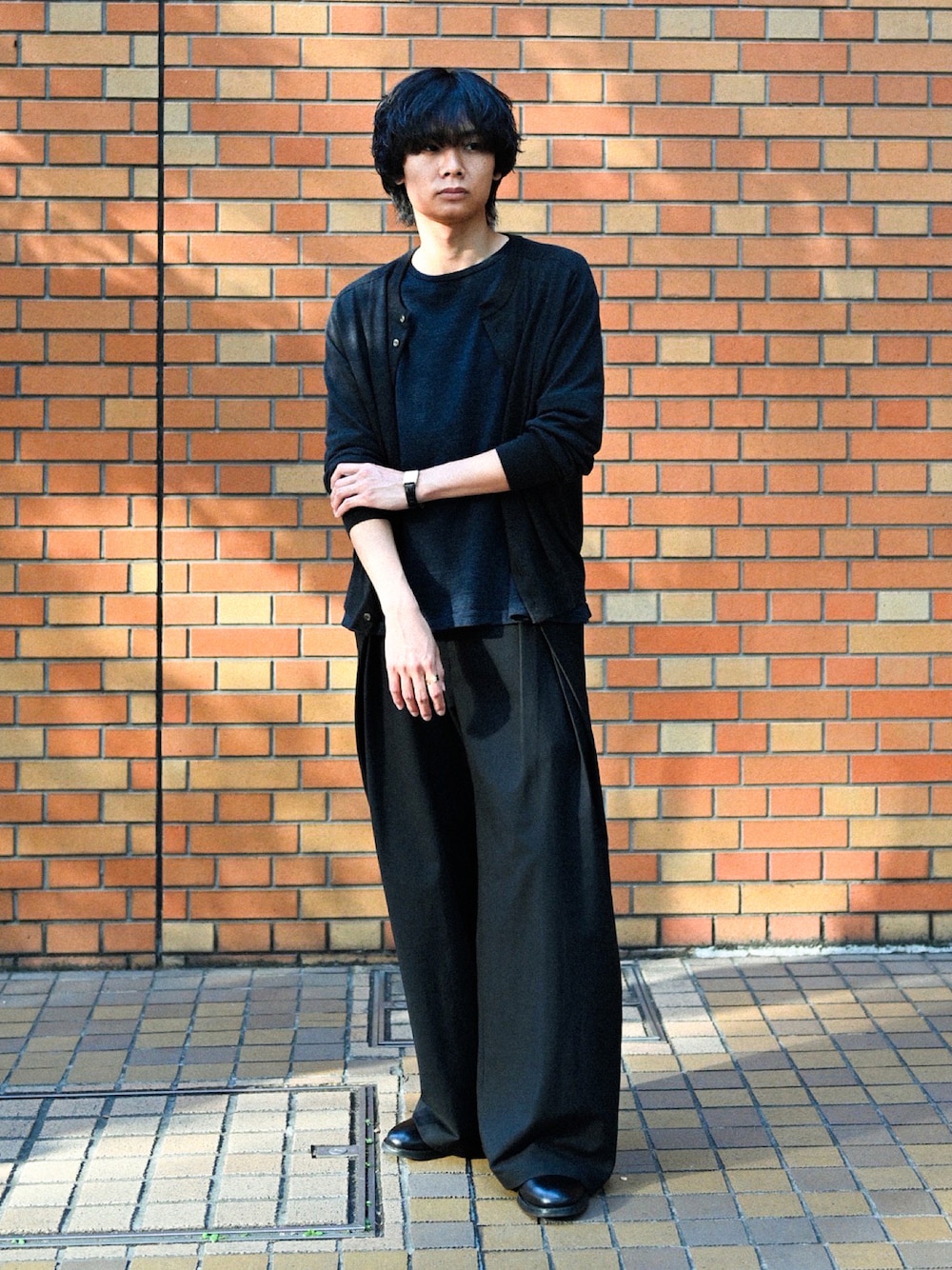 ブラック系のブーツ、ブラック系のスラックス、ブラック系のTシャツ/カットソーを着用したメンズの春コーディネートの1枚目の写真