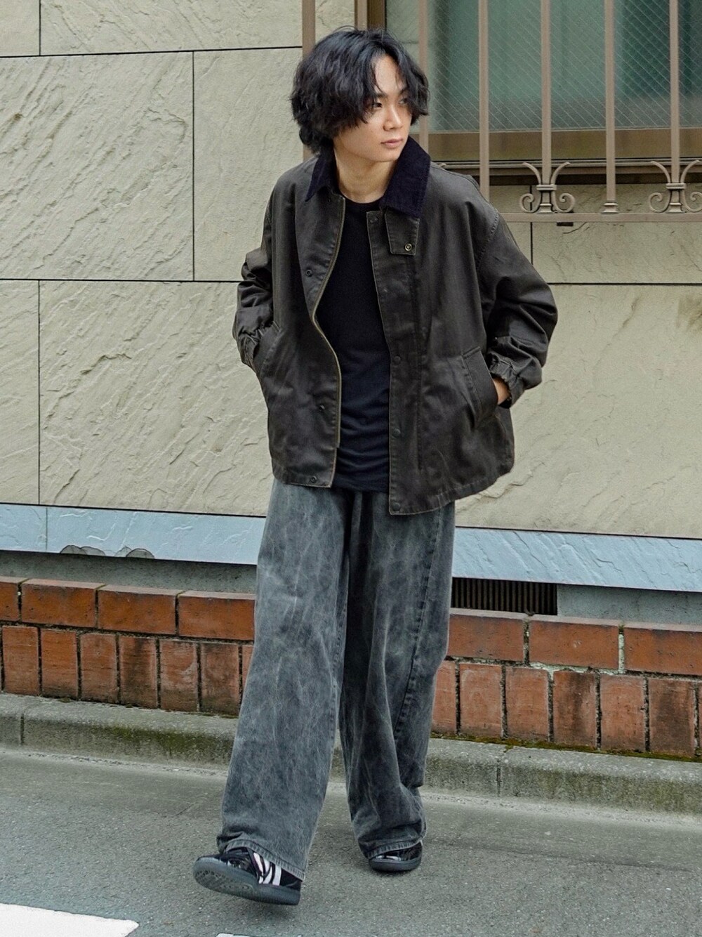 ブラウン系のブルゾン、ブラック系のデニムパンツ、ブラック系のTシャツ/カットソーを着用したメンズの秋コーディネートの1枚目の写真