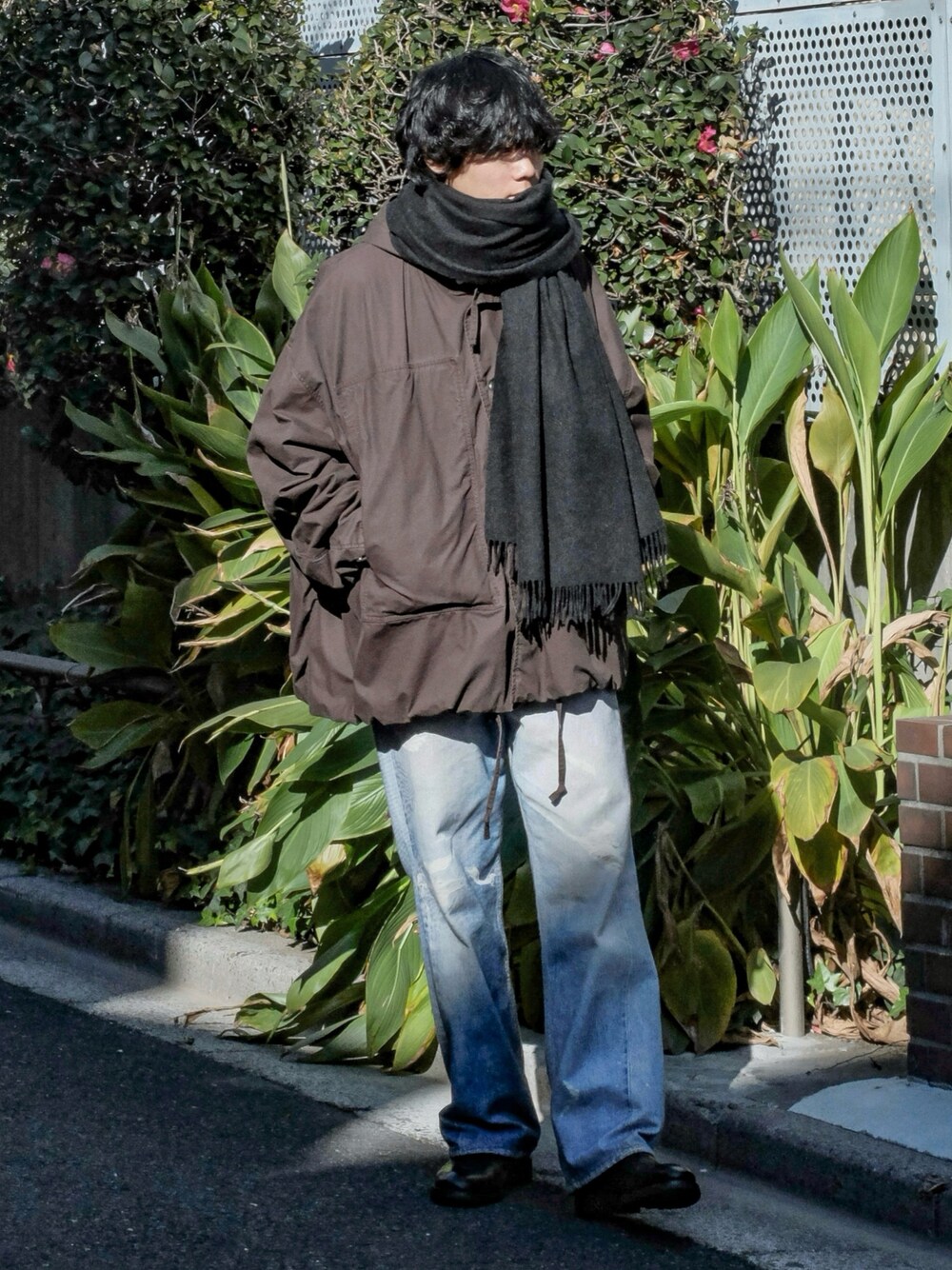 ブラウン系のブルゾン、ブルー系のデニムパンツ、ブラック系のブーツを着用したメンズの冬コーディネートの1枚目の写真