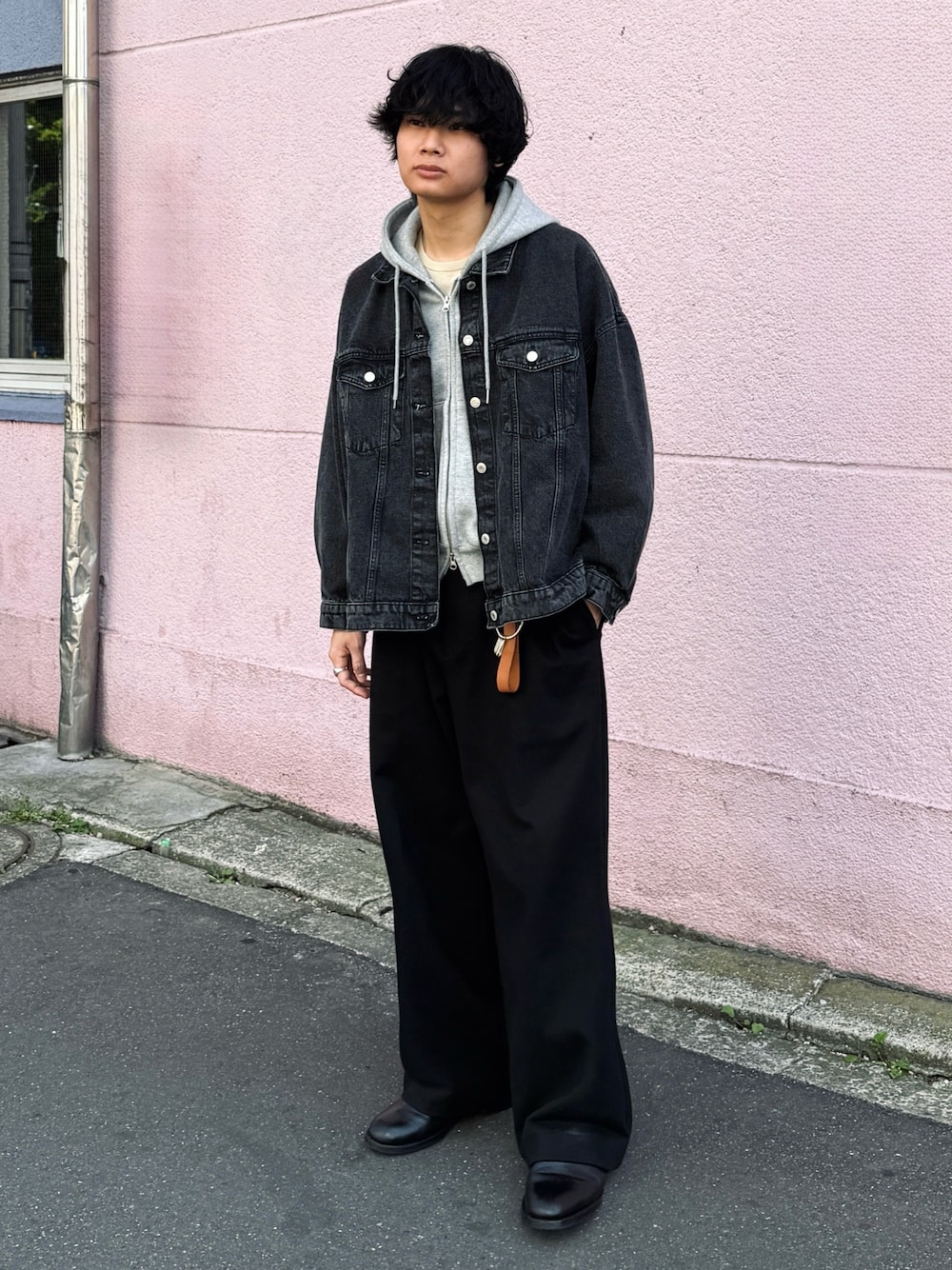 ブラック系のスラックス、ブラック系のブーツ、ブラック系のデニムジャケットを着用したメンズの春コーディネートの1枚目の写真