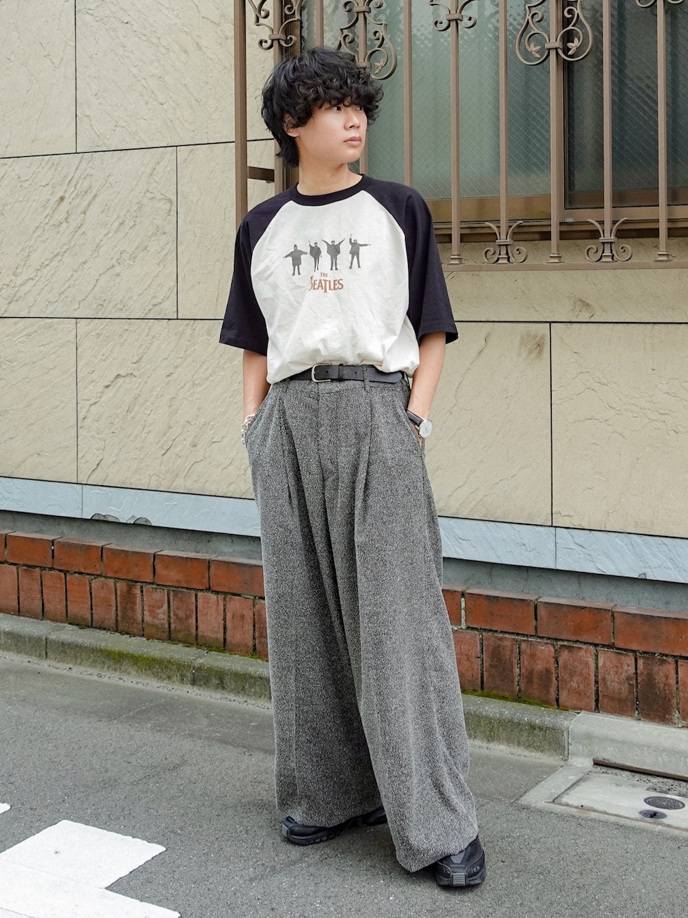 グレー系のスラックス、ホワイト系のTシャツ/カットソー、ブラック系のスニーカーを着用したメンズの夏コーディネートの1枚目の写真