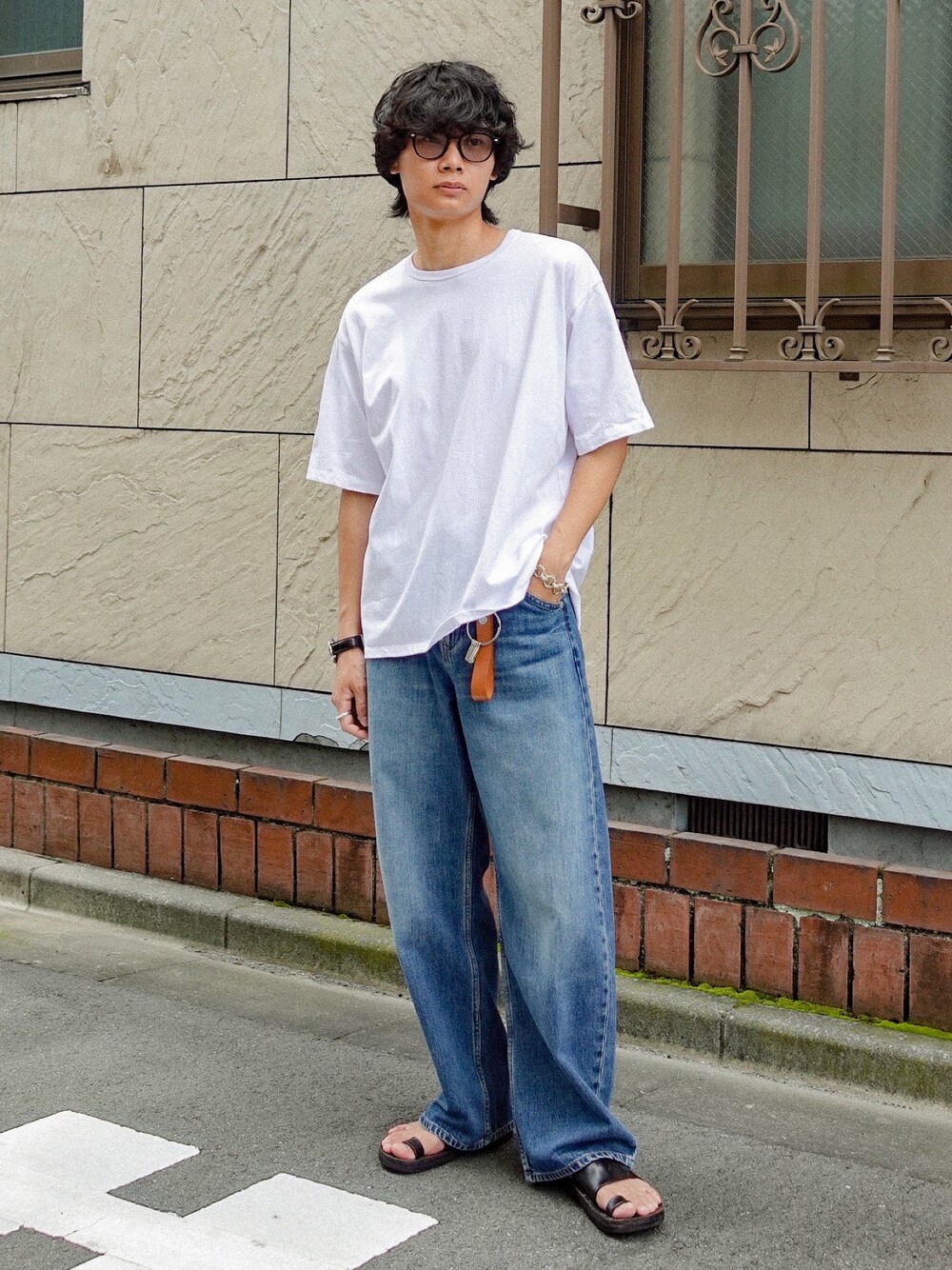 ブラック系のサンダル、ホワイト系のTシャツ/カットソー、ブルー系のデニムパンツを着用したメンズの夏コーディネートの1枚目の写真
