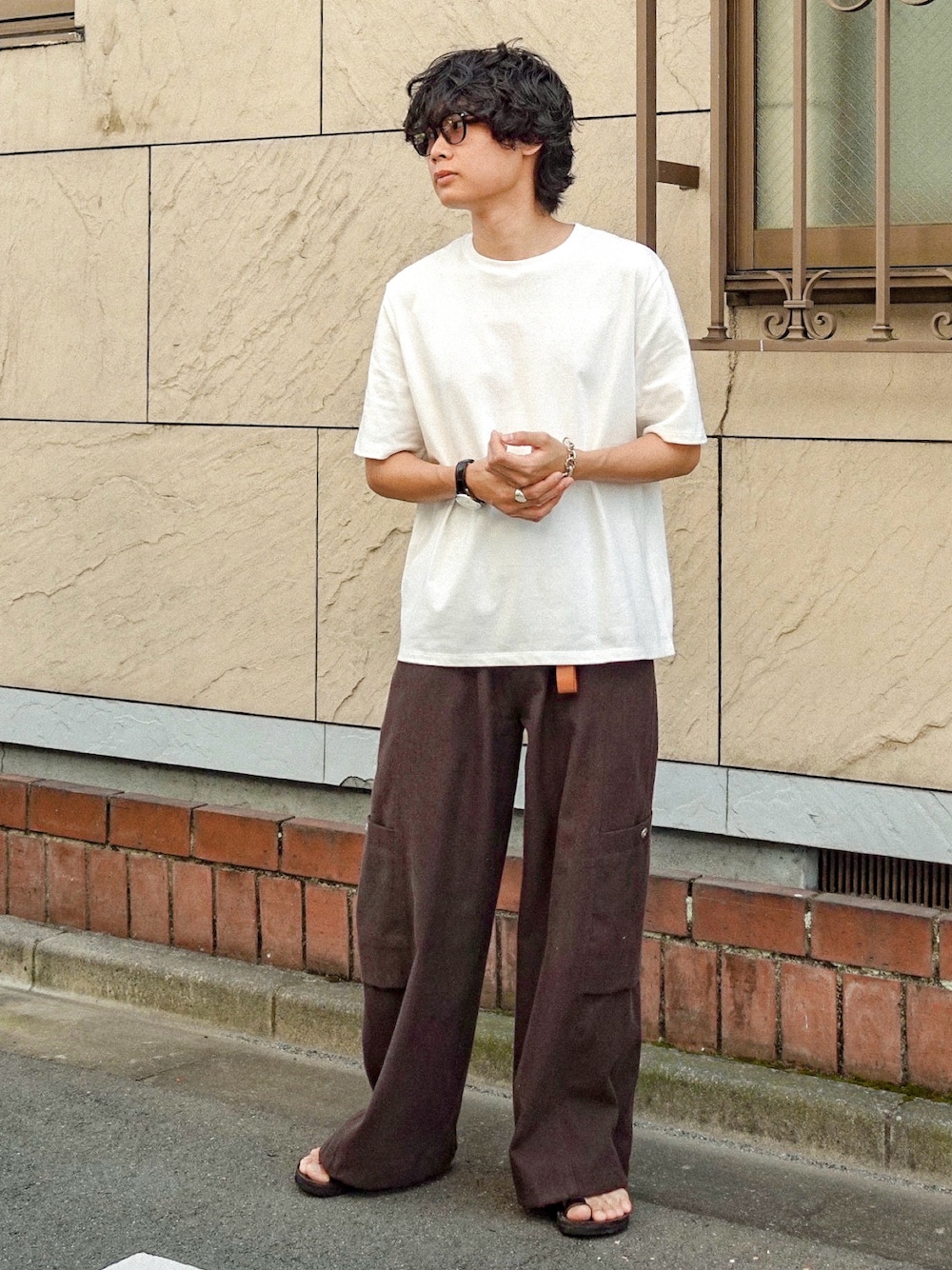 ホワイト系のTシャツ/カットソー、ブラック系のサンダル、ブラウン系のカーゴパンツを着用したメンズの夏コーディネートの1枚目の写真