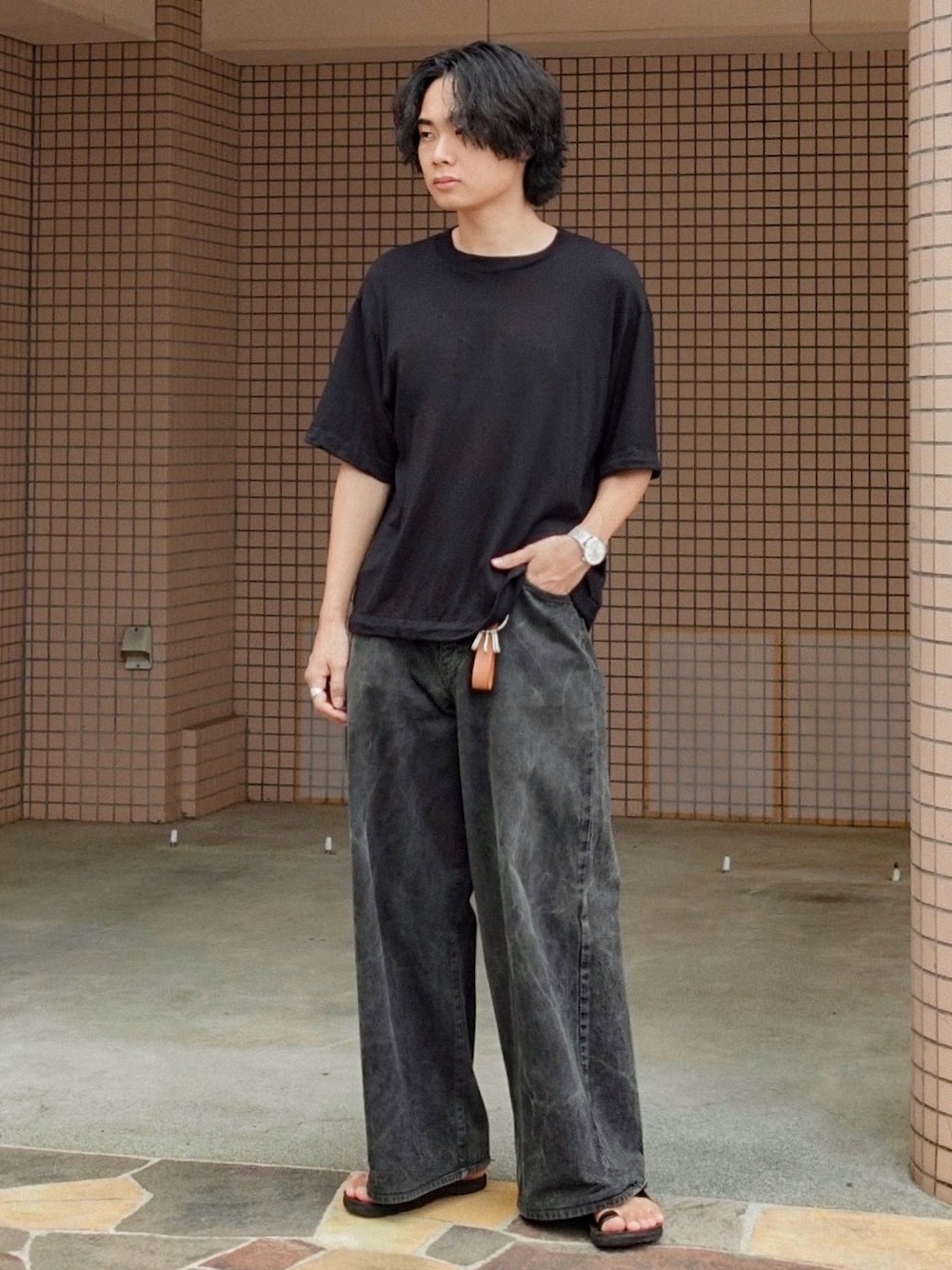 ブラック系のデニムパンツ、ブラック系のサンダル、ブラック系のTシャツ/カットソーを着用したメンズの秋コーディネートの1枚目の写真