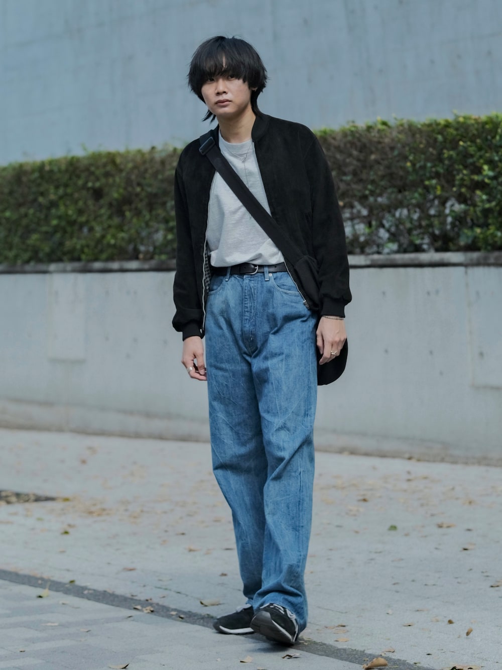 グレー系のTシャツ/カットソー、ブラック系のブルゾン、ブルー系のデニムパンツを着用したメンズの春コーディネートの1枚目の写真