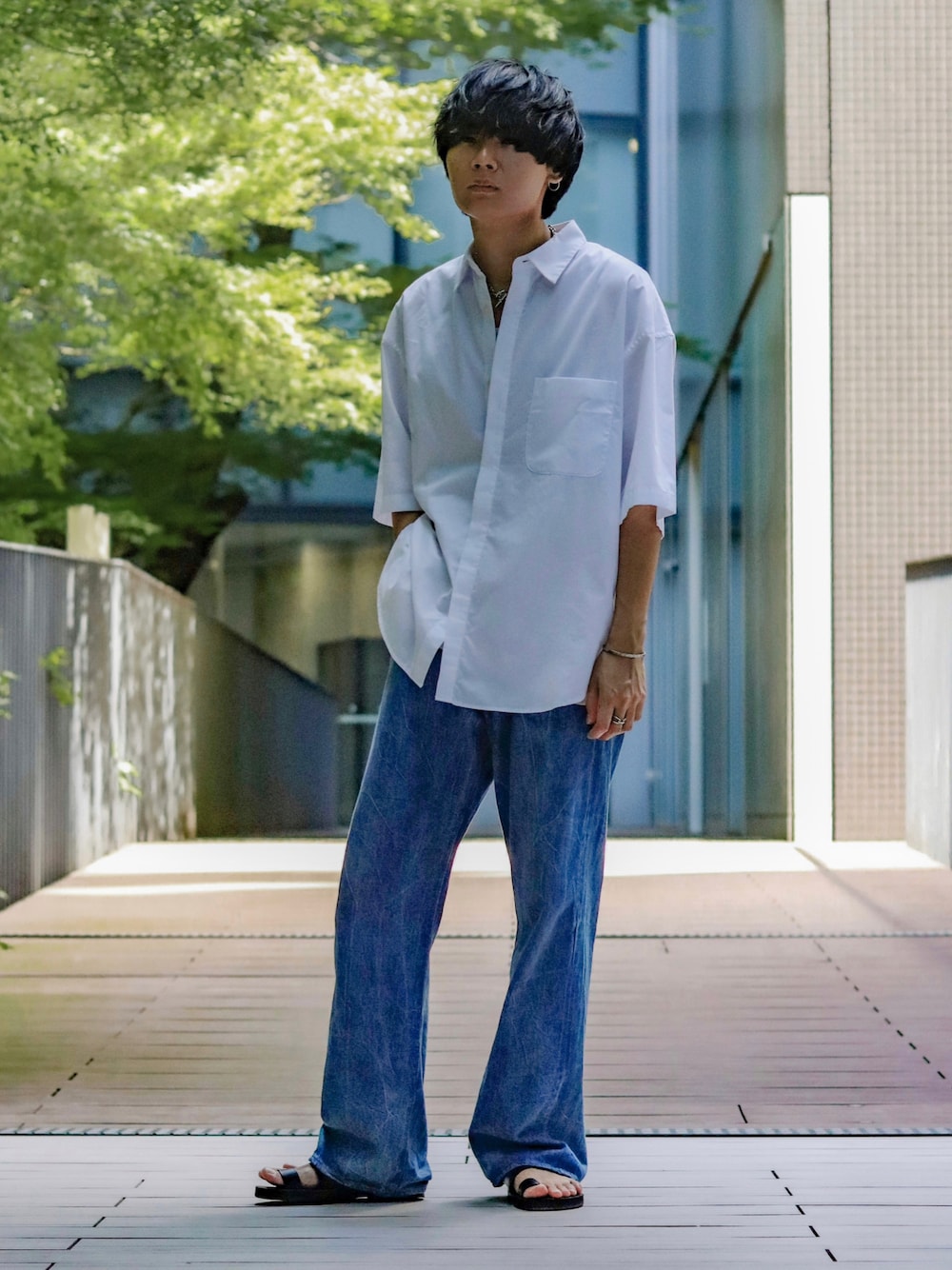 ブルー系のデニムパンツ、ホワイト系のシャツ/ブラウス、グレー系のタンクトップを着用したメンズの夏コーディネートの1枚目の写真