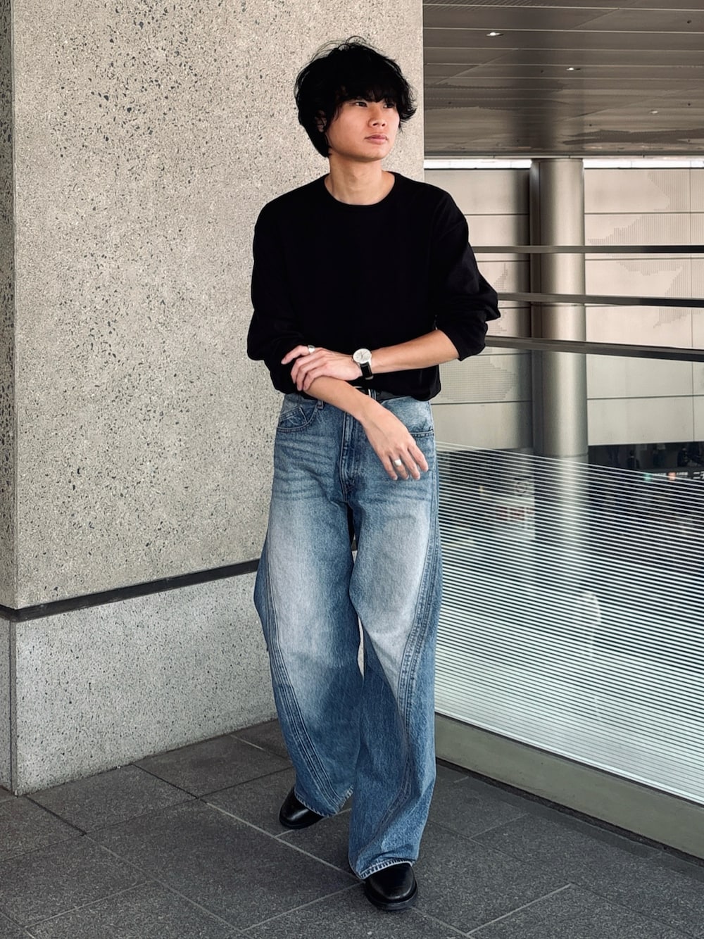 ブルー系のデニムパンツ、ブラック系のブーツ、ブラック系のTシャツ/カットソーを着用したメンズの春コーディネートの1枚目の写真