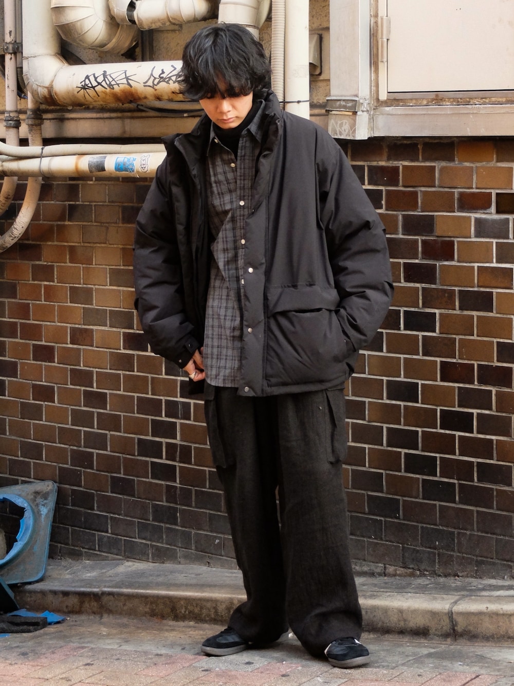 ブラック系のダウンジャケット/コート、グレー系のシャツ/ブラウス、グレー系のニット/セーターを着用したメンズの冬コーディネートの1枚目の写真