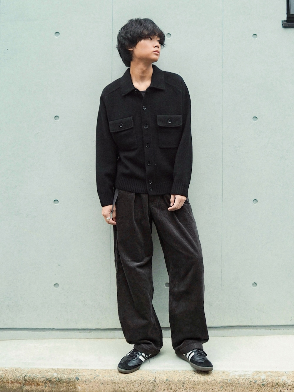 ブラック系のその他パンツ、ブラック系のニット/セーター、ブラック系のスニーカーを着用したメンズの秋コーディネートの1枚目の写真