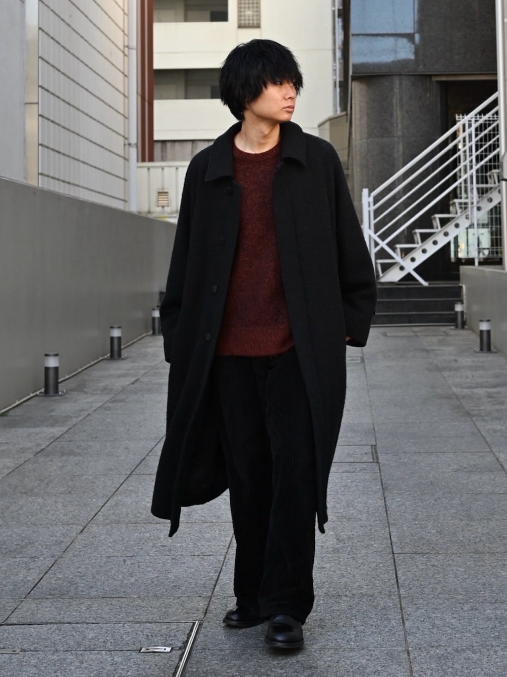 ブラック系のブーツ、ブラック系のその他アウター、ブラウン系のニット/セーターを着用したメンズの冬コーディネートの1枚目の写真