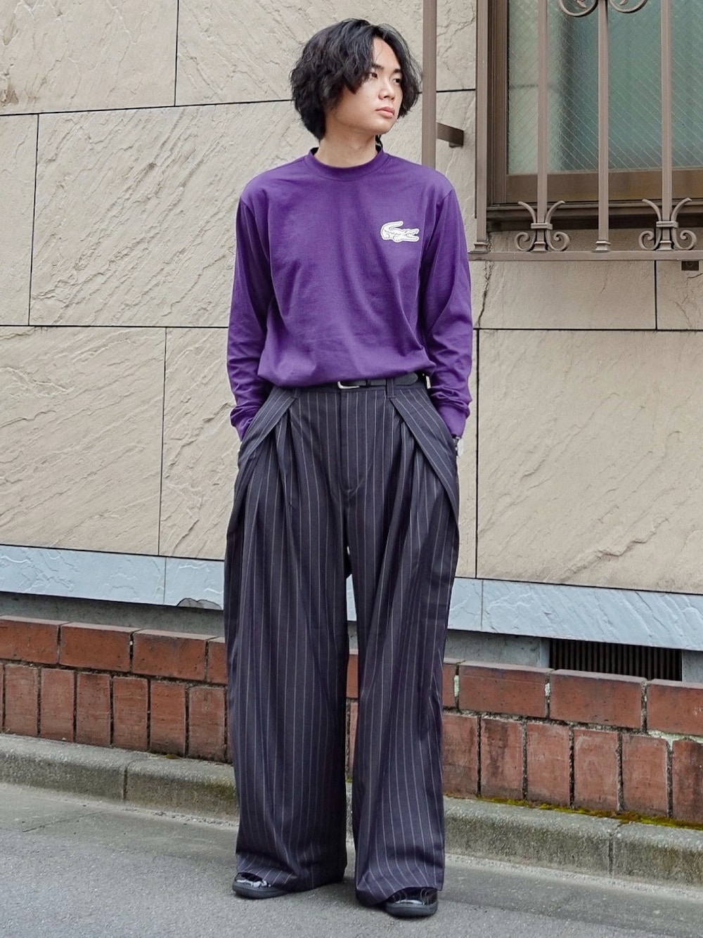 パープル系のTシャツ/カットソー、グレー系のスラックス、ブラック系のアナログ腕時計を着用したメンズの秋コーディネートの1枚目の写真