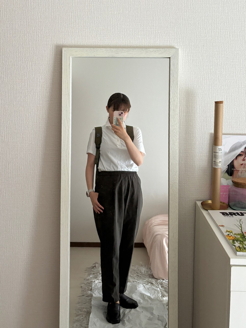 ブラック系のローファー、グリーン系のパンツ、ホワイト系のポロシャツを着用したレディースの夏コーディネートの1枚目の写真