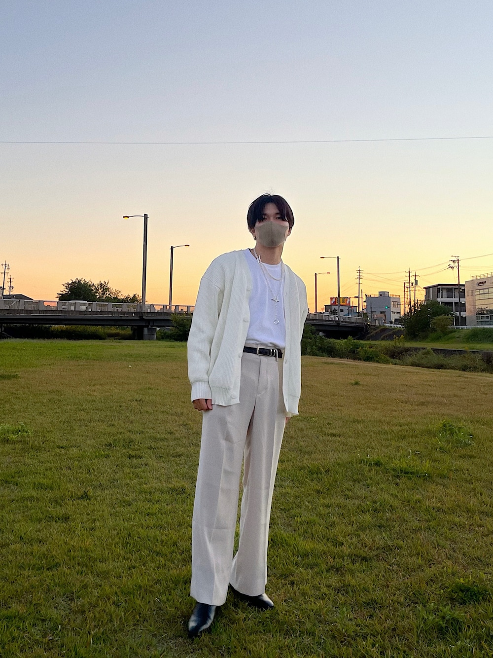 ホワイト系のカーディガン/ボレロ、ホワイト系のTシャツ/カットソー、ベージュ系のスラックスを着用したメンズの秋コーディネートの1枚目の写真