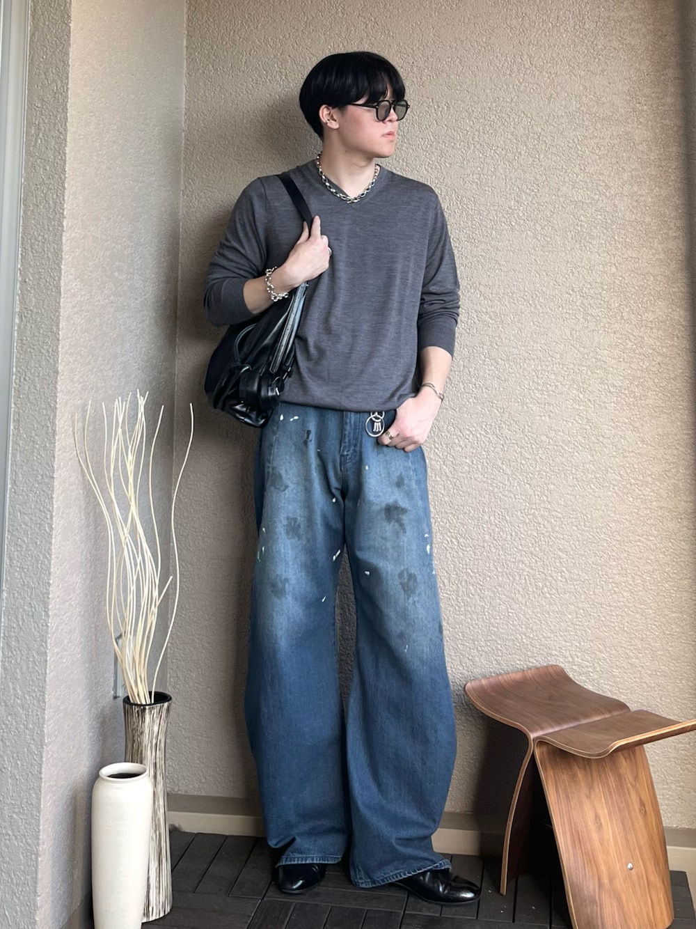 ブラック系のショルダーバッグ、ブルー系のデニムパンツ、ブラック系のドレスシューズを着用したメンズの秋コーディネートの1枚目の写真