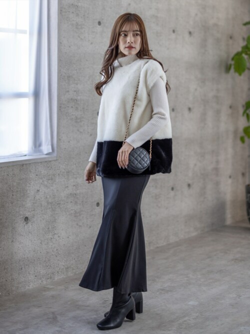ホワイト系のニット/セーター、ブラック系のTシャツ/カットソー、ブラック系のスカートを着用したレディースの秋コーディネートの1枚目の写真