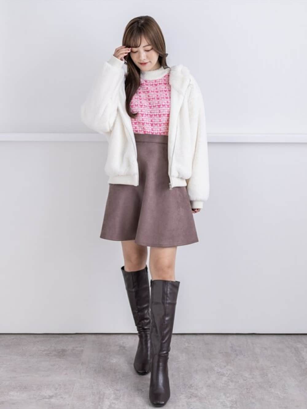 ピンク系のニット/セーター、ブラウン系のスカート、ホワイト系のブルゾンを着用したレディースの冬コーディネートの1枚目の写真