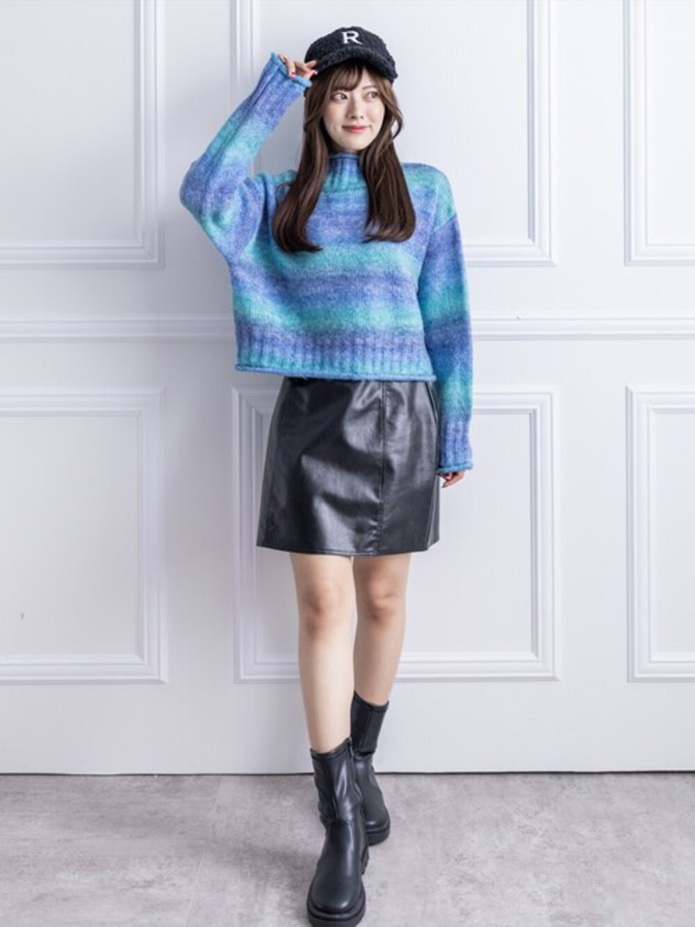 ブルー系のニット/セーター、ブラック系のスカート、ブラック系のブーツを着用したレディースの冬コーディネートの1枚目の写真