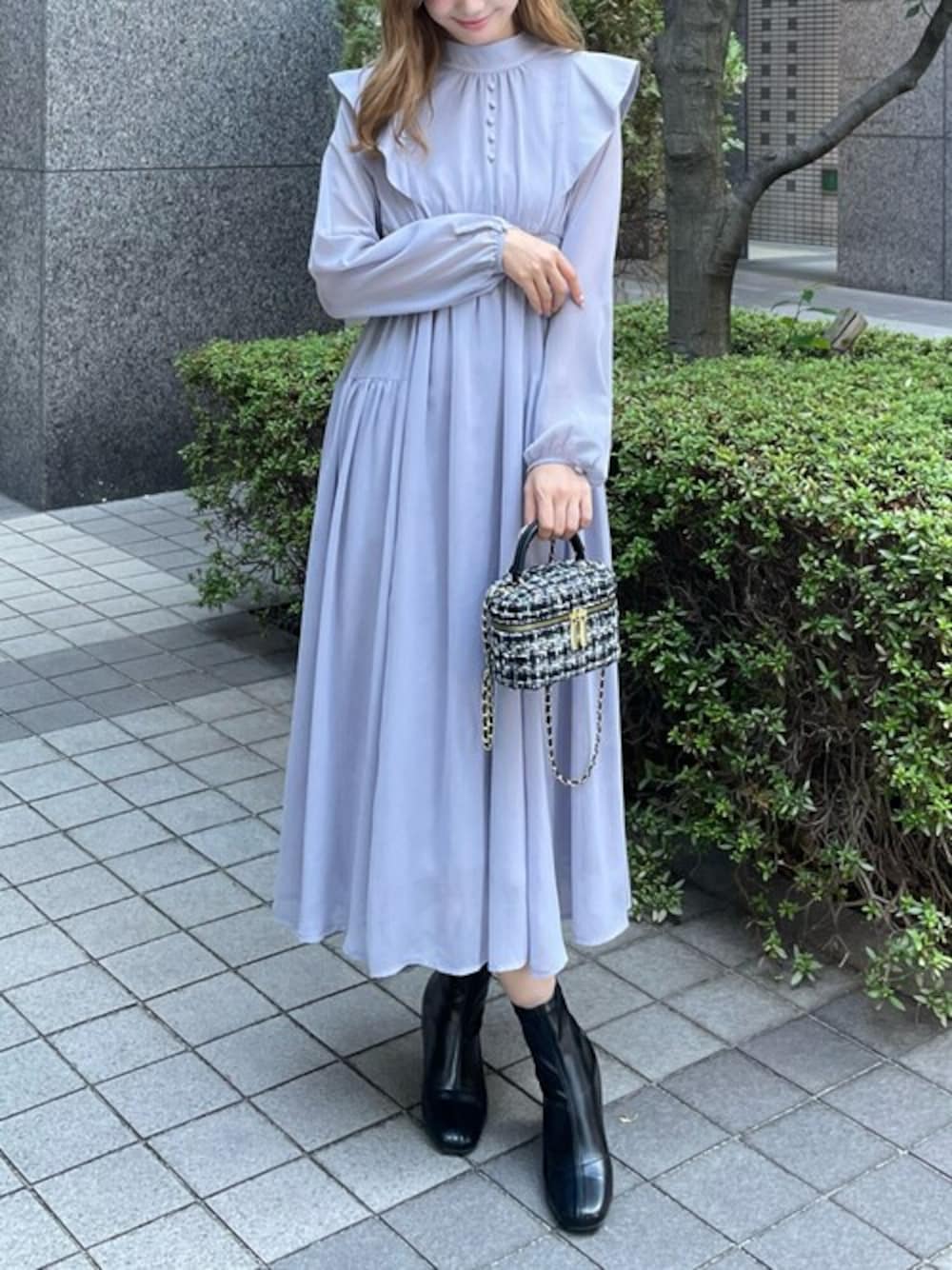 グレー系のワンピース、ブラック系のブーツ、ブラック系のショルダーバッグを着用したレディースの秋コーディネートの1枚目の写真