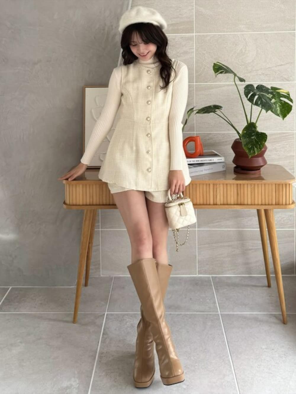 ホワイト系のチュニック、ホワイト系のニット/セーター、ベージュ系のブーツを着用したレディースの冬コーディネートの1枚目の写真