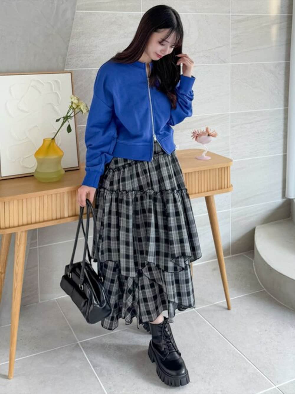 ブルー系のTシャツ/カットソー、ブラック系のスカート、ブラック系のブーツを着用したレディースの冬コーディネートの1枚目の写真