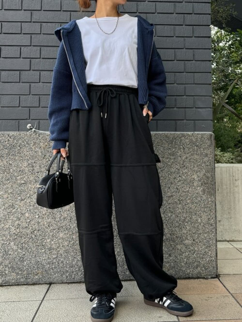 ブラック系のスウェットパンツ、ブルー系のパーカーを着用したレディースの秋コーディネートの1枚目の写真