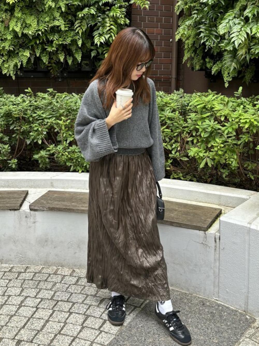 グリーン系のスカート、グレー系のニット/セーターを着用したレディースの秋コーディネートの1枚目の写真