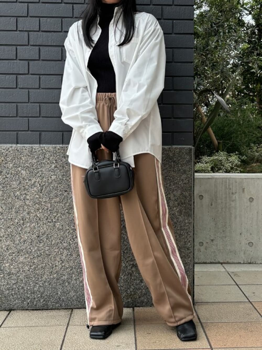 ベージュ系のその他パンツ、ブラック系のニット/セーター、ホワイト系のシャツ/ブラウスを着用したレディースの冬コーディネートの1枚目の写真