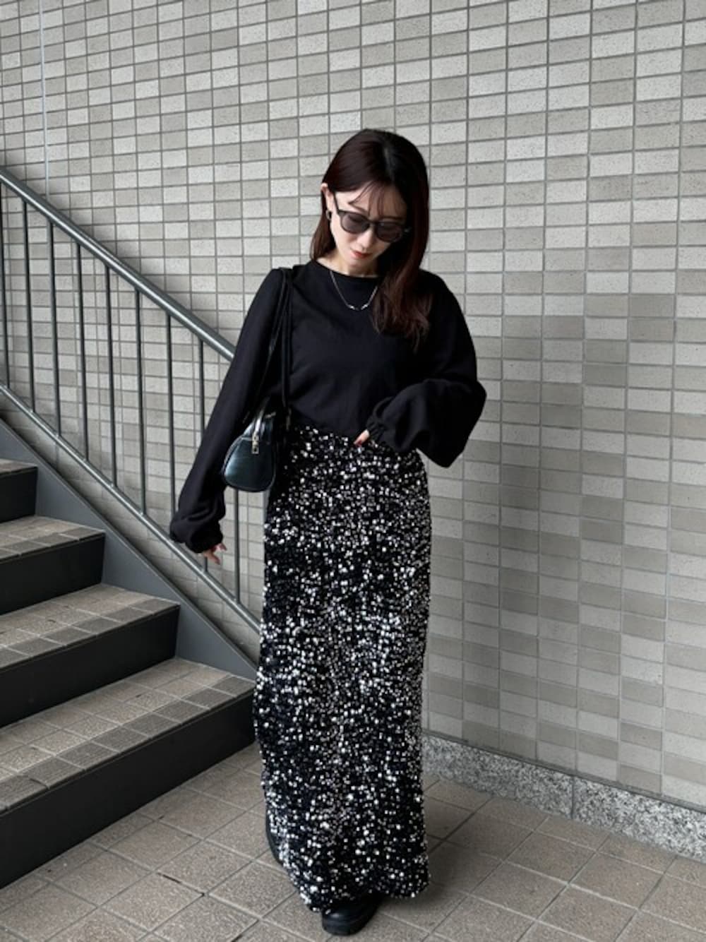 ブラック系のスカートを着用したレディースの冬コーディネートの1枚目の写真