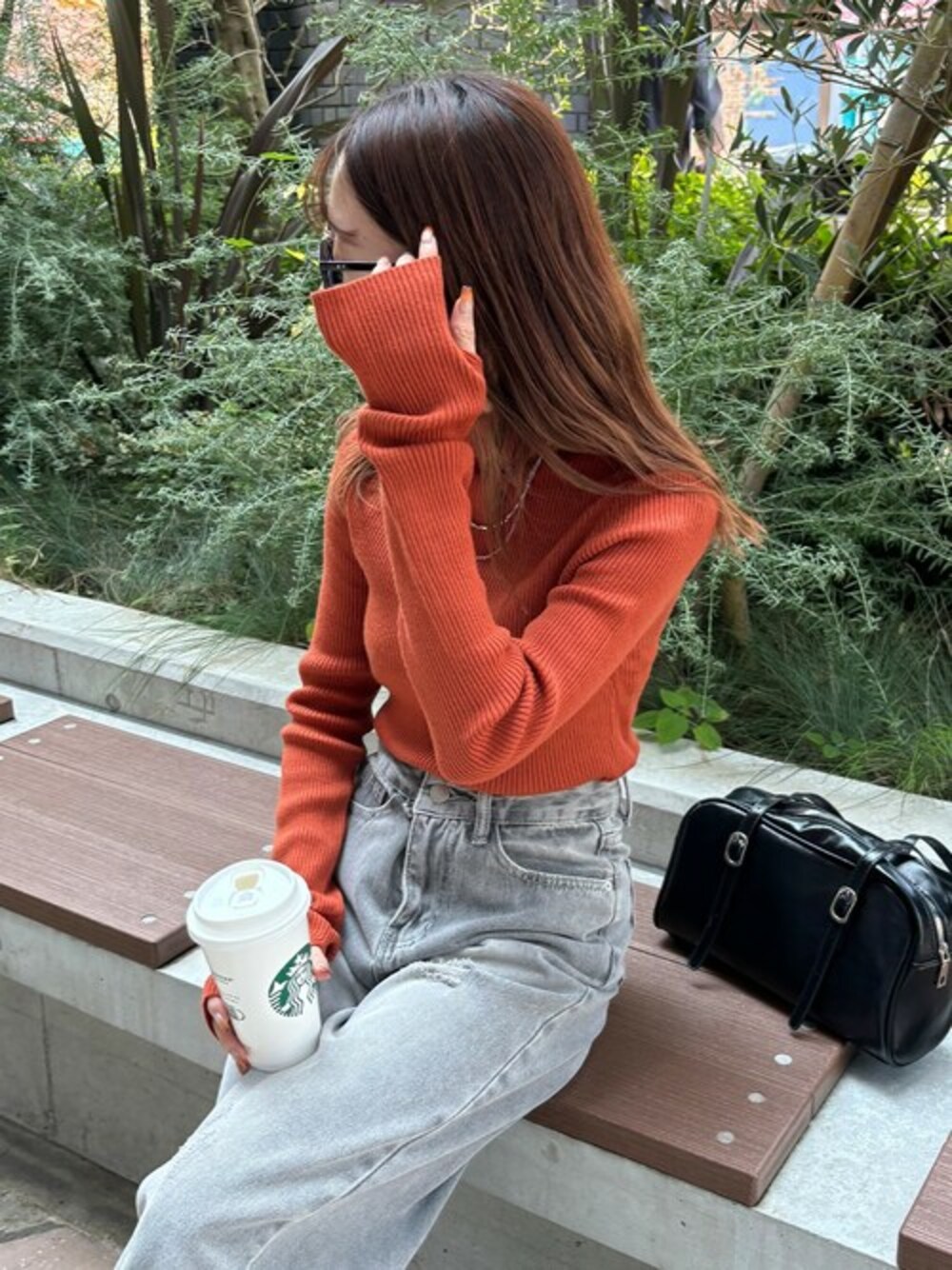 オレンジ系のニット/セーターを着用したレディースの冬コーディネートの1枚目の写真