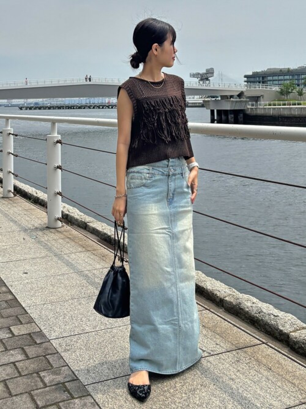 ブラウン系のタンクトップ、ブルー系のデニムスカートを着用したレディースの夏コーディネートの1枚目の写真