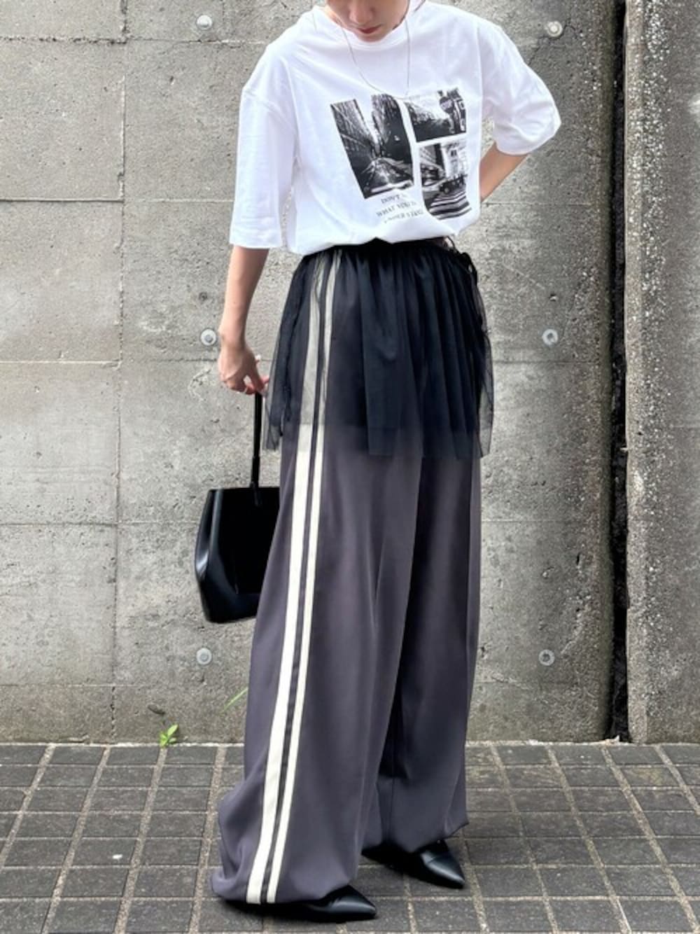 ホワイト系のTシャツ/カットソー、グレー系のスラックス、ブラック系のスカートを着用したレディースの夏コーディネートの1枚目の写真