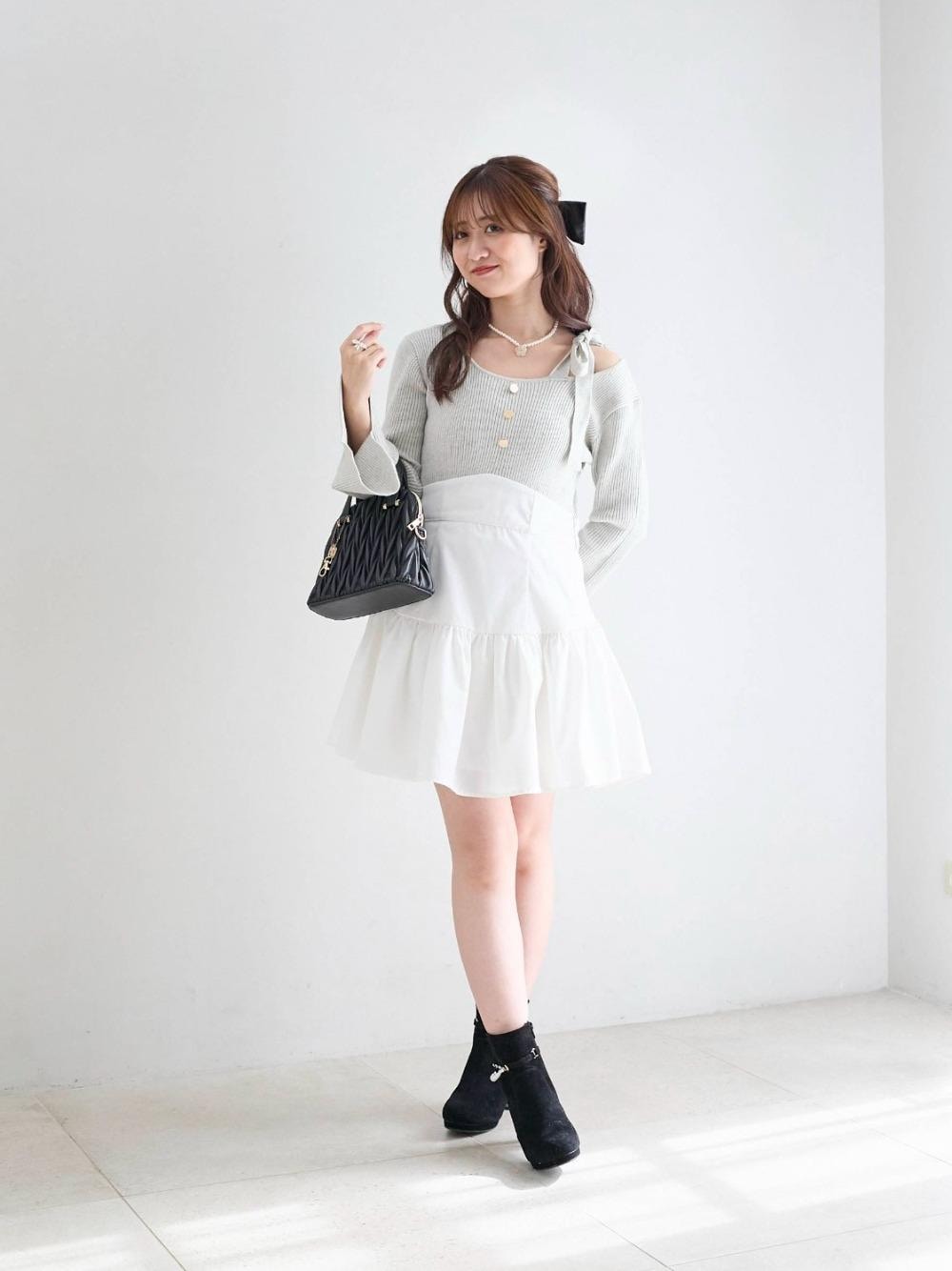 ブラック系のショルダーバッグ、ブラック系のブーツ、グレー系のワンピースを着用したレディースの冬コーディネートの1枚目の写真