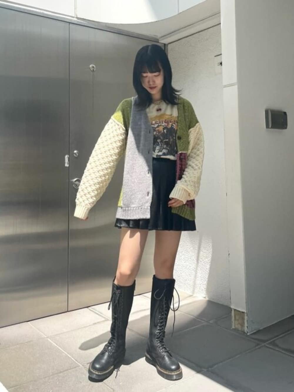 グレー系のカーディガン/ボレロ、ブラック系のスカートを着用したレディースの夏コーディネートの1枚目の写真