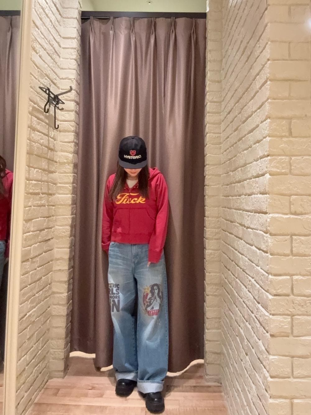 ブルー系のデニムパンツ、レッド系のパーカー、ブラック系のキャップを着用したレディースの秋コーディネートの1枚目の写真