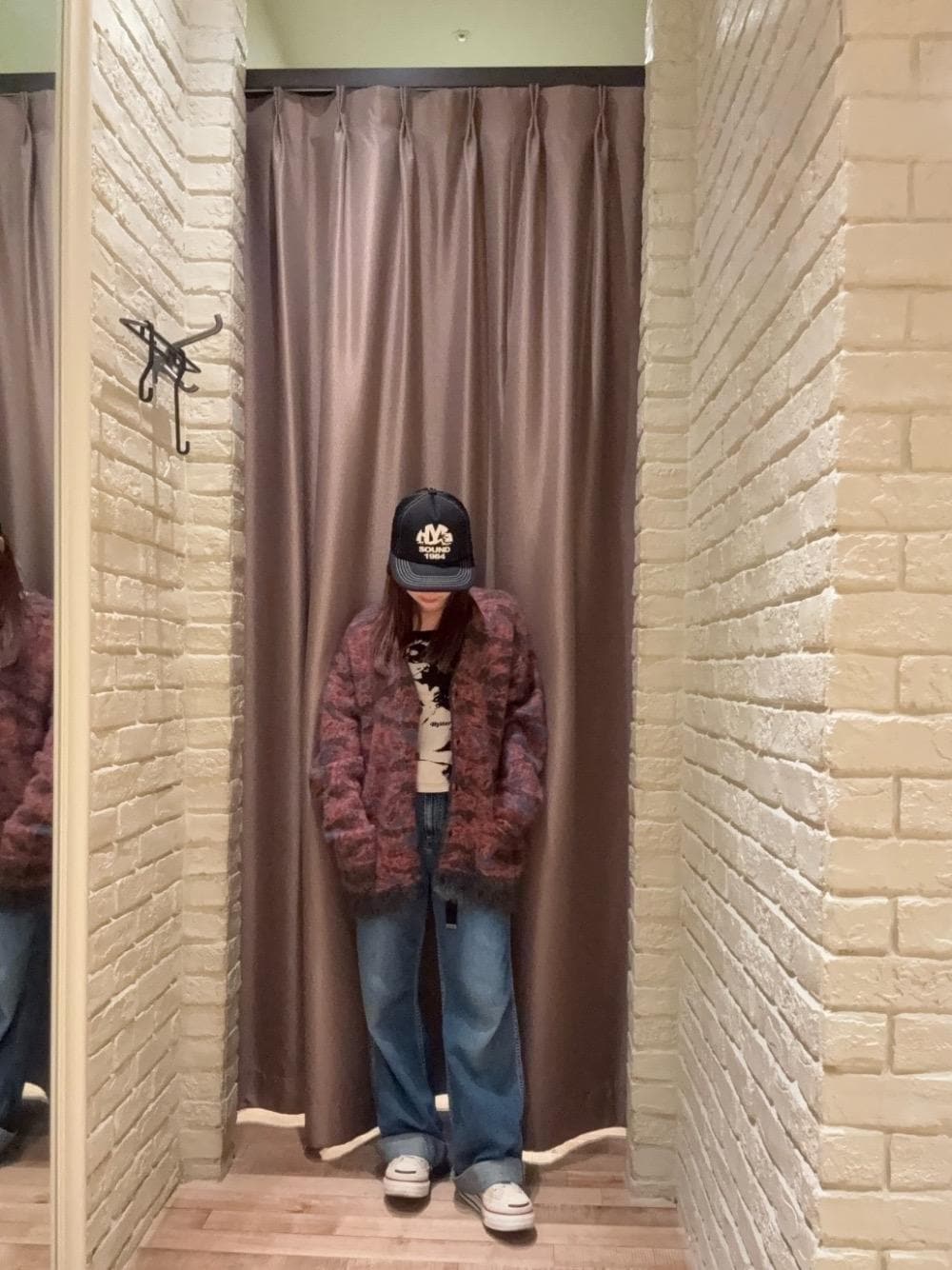 オレンジ系のカーディガン/ボレロ、ブラック系のTシャツ/カットソー、ブラック系のキャップを着用したレディースの秋コーディネートの1枚目の写真