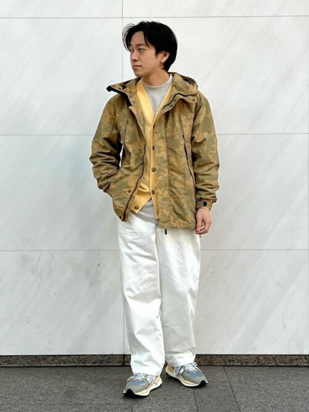 イエロー系のカーディガン/ボレロ、ベージュ系のTシャツ/カットソー、ホワイト系のチノパンツを着用したメンズの春コーディネートの1枚目の写真