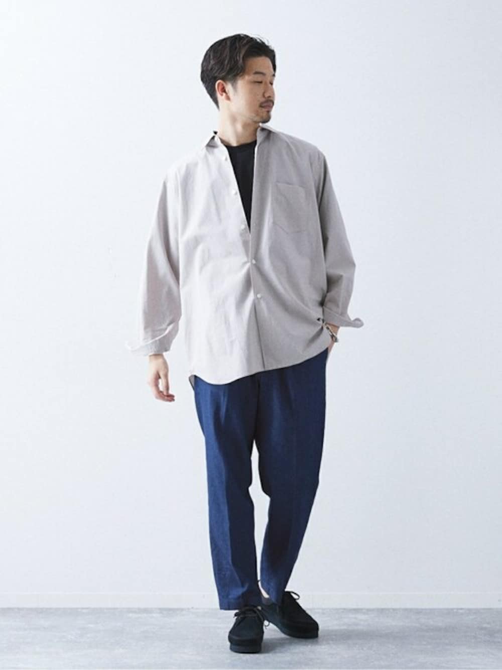 ブルー系のデニムパンツ、ベージュ系のシャツ/ブラウス、ブラック系のスニーカーを着用したメンズの春コーディネートの1枚目の写真