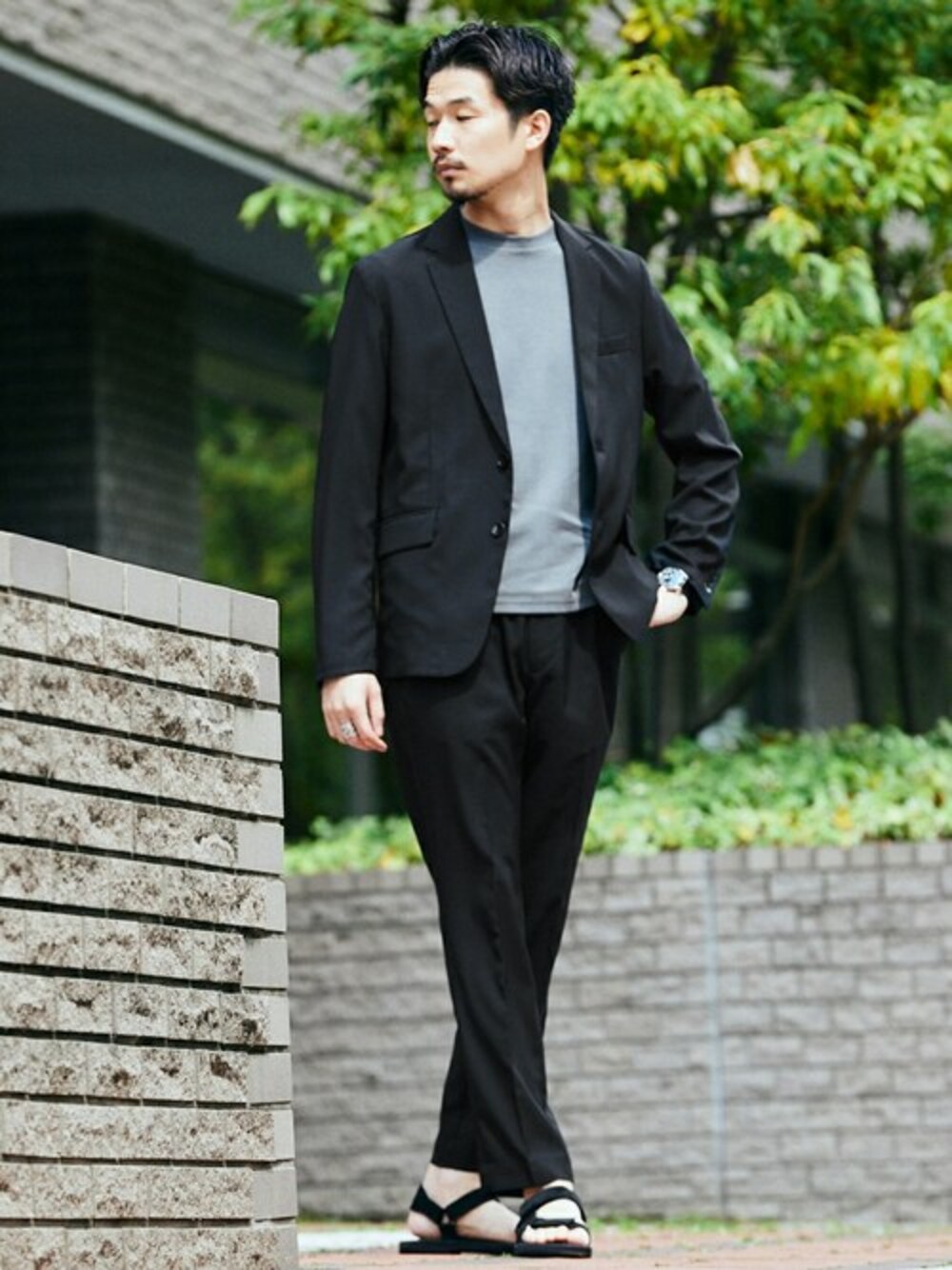 ブラック系のセットアップ、グレー系のTシャツ/カットソー、ブラック系のサンダルを着用したメンズの春コーディネートの1枚目の写真