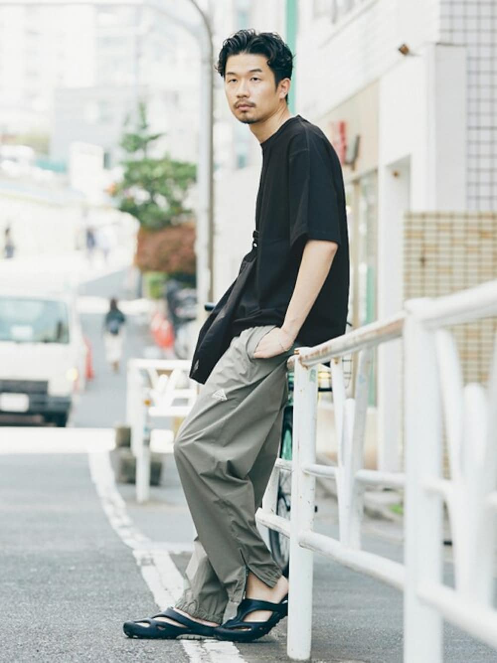 ブラック系のTシャツ/カットソー、グリーン系のカーゴパンツを着用したメンズの春コーディネートの1枚目の写真