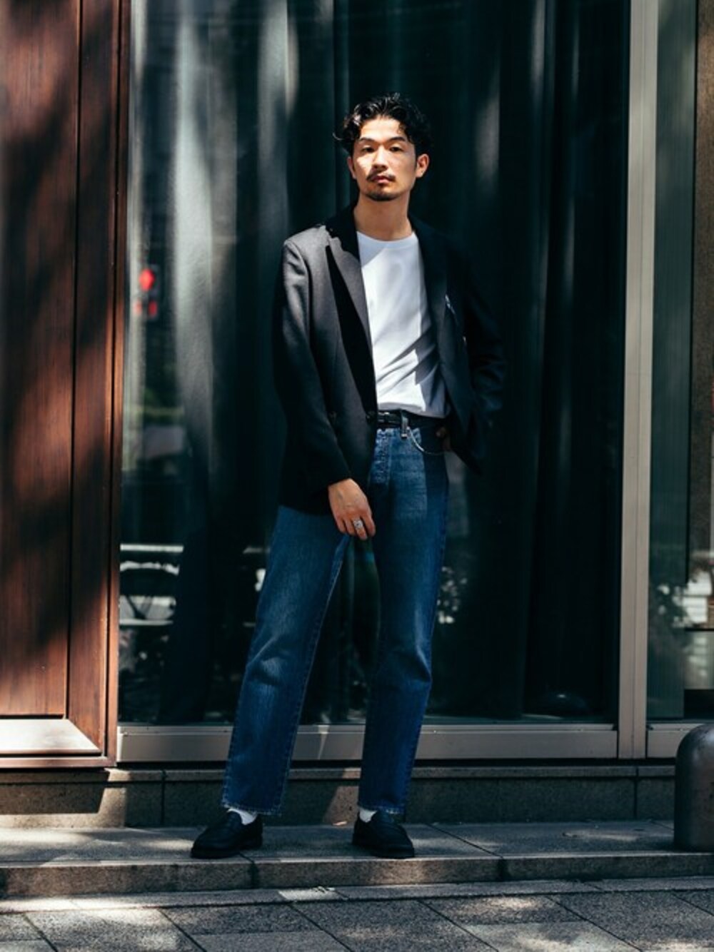 ブルー系のデニムパンツ、ホワイト系のTシャツ/カットソー、ブラック系のローファーを着用したメンズの夏コーディネートの1枚目の写真