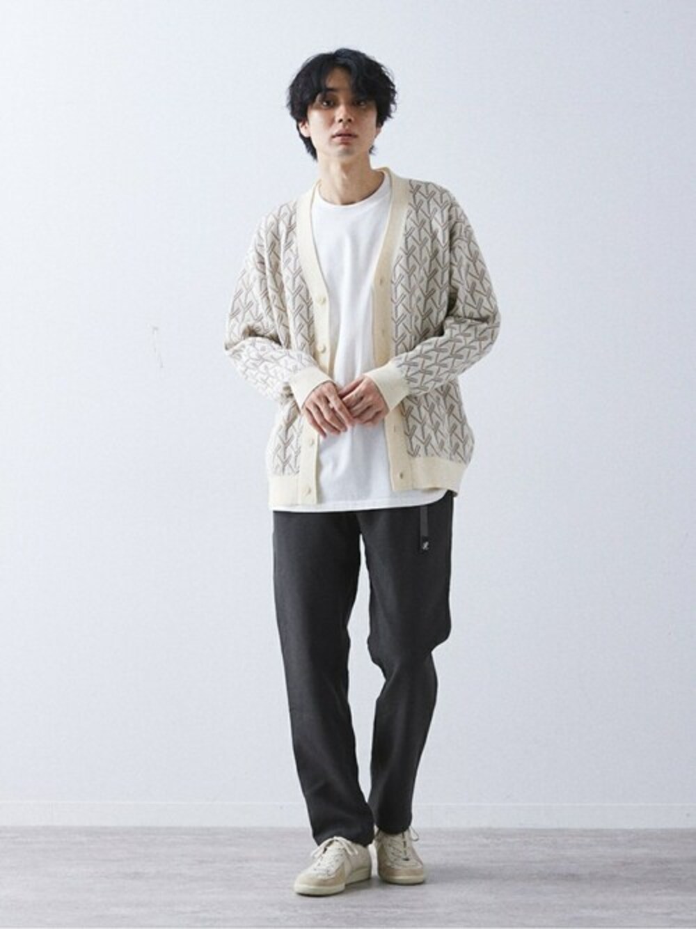 ホワイト系のカーディガン/ボレロ、グレー系のスラックス、ホワイト系のスニーカーを着用したメンズの秋コーディネートの1枚目の写真
