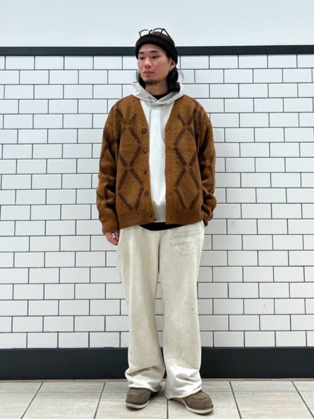 ベージュ系のカーディガン/ボレロ、ホワイト系のパーカーを着用したメンズの秋コーディネートの1枚目の写真